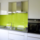 Küche: Front Hochglanz mit Griffleisten, Nischenrückwand aus Glas